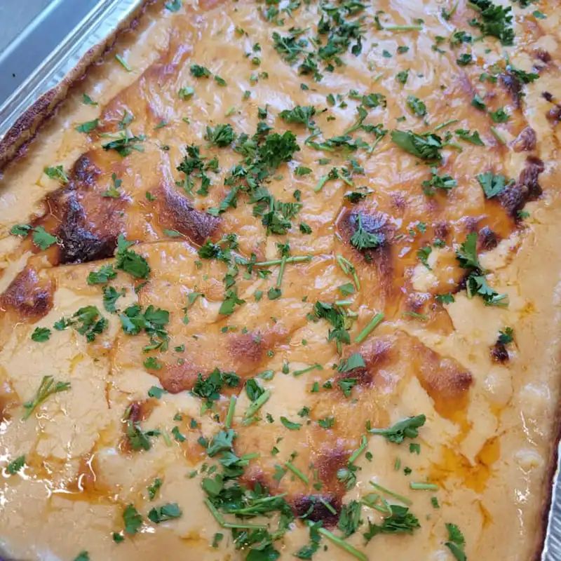 Pan of baked ziti with parsley from the oven