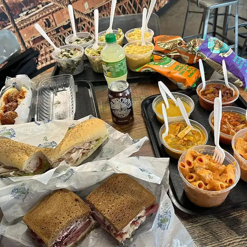 Lunch spread with sandwiches, soups, salads, and drinks