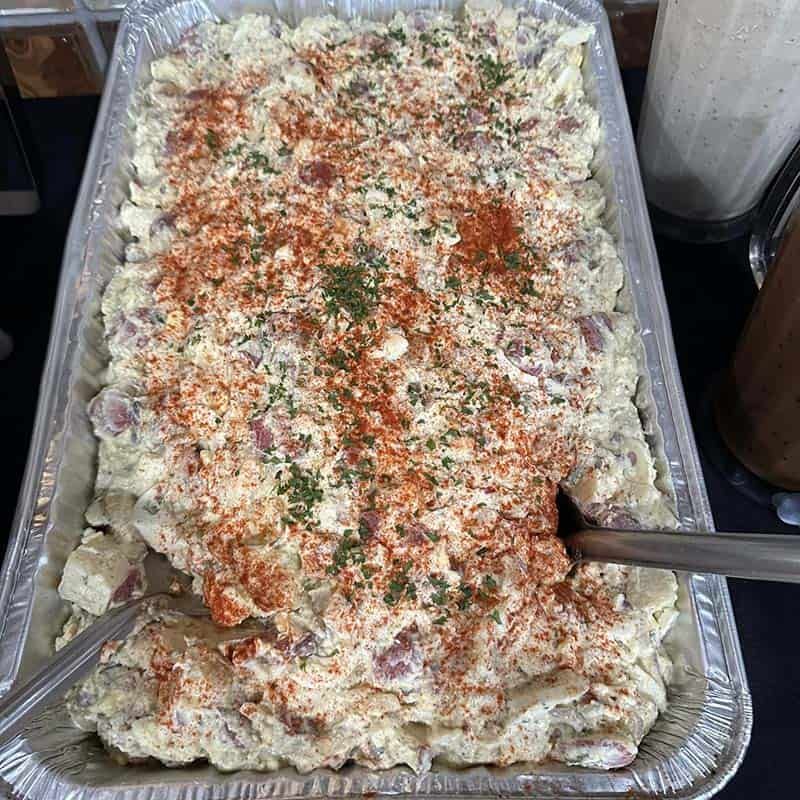 Full catering pan of homemade potato salad with paprika