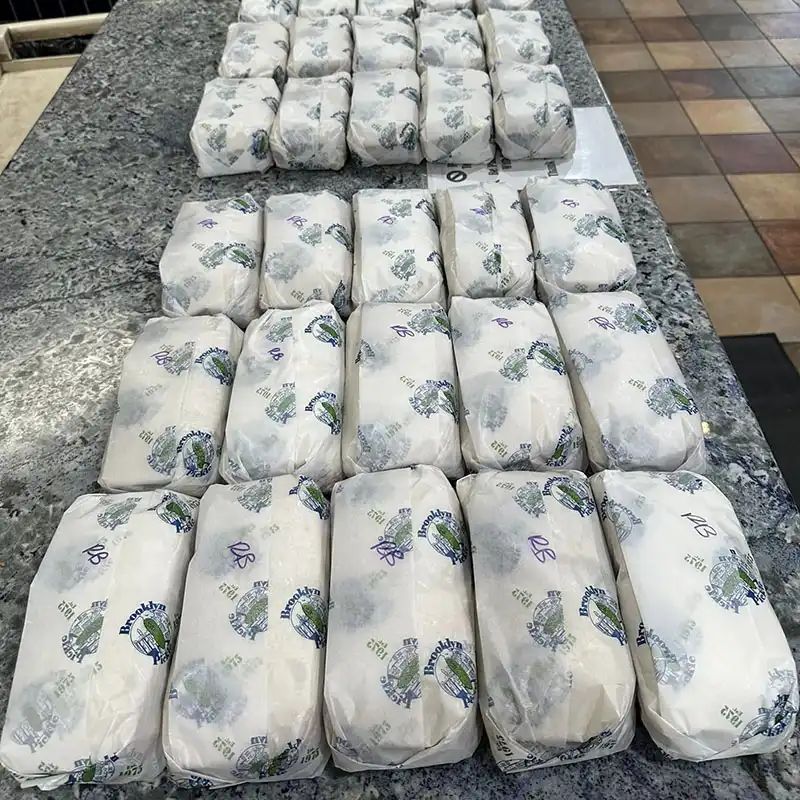 Rows of wrapped sandwiches in Brooklyn Pickle deli paper ready for delivery