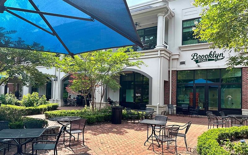 Brooklyn Pickle Raleigh patio with shade sails and cafe tables
